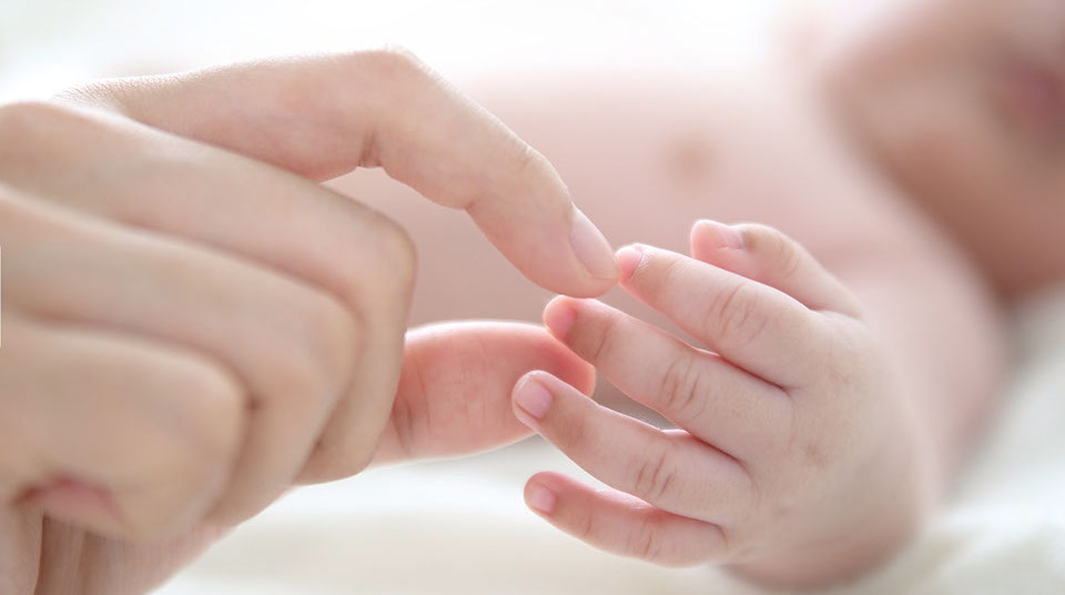 mom's hand holding her baby's